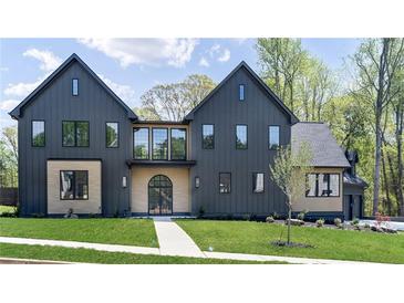 Stunning modern home with dark siding, complemented by well-manicured lawn and beautiful architectural details at 115 Nova Ln, Roswell, GA 30075