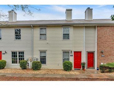Charming townhome featuring a red front door, neutral siding, and well-maintained landscaping at 992 Old Holcomb Bridge Rd, Roswell, GA 30076