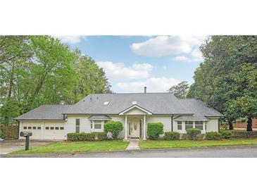 Charming single-story home featuring a well-maintained lawn, a two-car garage, and a welcoming front entrance at 2988 Chipmunk Se Trl, Marietta, GA 30067