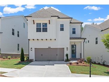 Charming two-story home with a gray two car garage and a landscaped front yard at 627 Skytop Dr, Cumming, GA 30040