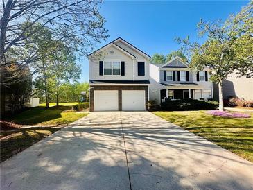 Charming two-story home with a two-car garage and a long driveway, surrounded by lush greenery at 5485 Mountain Top Pl, Cumming, GA 30041