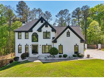 Beautiful two-story home with brick exterior, black trim, landscaped front yard, and mature trees at 1961 Flowering Dr, Grayson, GA 30017