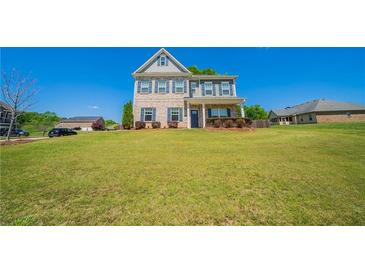 Charming two-story home with a well-manicured lawn and traditional architectural details at 10 Edgewater Ct, Covington, GA 30016