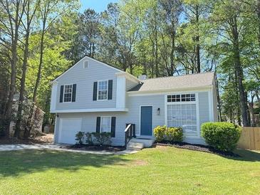 Charming two-story home featuring a well-manicured lawn and inviting curb appeal nestled in a wooded area at 6213 Marbut Farms Chase, Lithonia, GA 30058