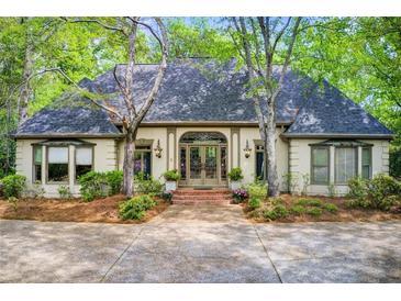 Charming home featuring a symmetrically designed exterior with a gray roof and beautiful front yard landscaping at 305 Heards Ferry Rd, Atlanta, GA 30328