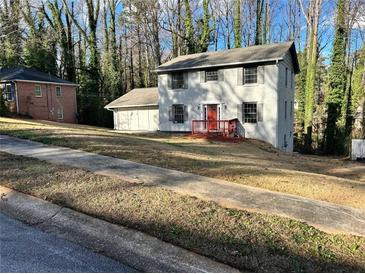 Charming two-story home with a red front porch and well-maintained lawn surrounded by mature trees at 4844 Fairforest Dr, Stone Mountain, GA 30088