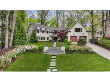 Stunning white brick home featuring a beautifully landscaped front yard and two-car garage at 4431 Skyland Ne Dr, Atlanta, GA 30342