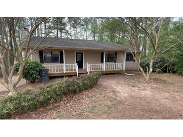 Charming single-story home featuring a cozy front porch nestled among mature trees at 99 Fox Ridge Ct, Dallas, GA 30157