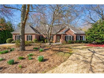Charming single-story brick home with a well-manicured lawn and mature trees, offering classic curb appeal at 4185 Waterford Dr, Suwanee, GA 30024