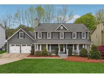 Charming two-story home with a welcoming front porch and well-manicured lawn and a two car garage at 2597 Oak Village Ne Pl, Marietta, GA 30062