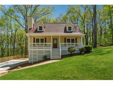 Inviting two-story home with covered front porch, white railings, and a well-manicured lawn at 388 Pine Trl, Canton, GA 30115
