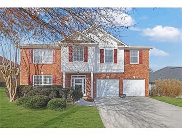 Charming two-story brick home with red shutters and a two-car garage, all under a clear blue sky at 3184 Elmwood Ct, Atlanta, GA 30349