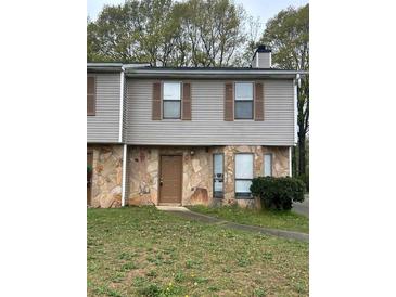 Charming two-story home with stone accents and neutral siding, complemented by well-maintained landscaping at 3634 Hopkins Ct, Powder Springs, GA 30127