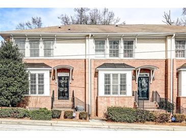 Charming townhome featuring a classic brick facade, black awnings, and well-maintained landscaping at 7 Chief Matthews Rd # 2A, Decatur, GA 30030