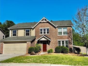 Inviting two-story brick home featuring a well-manicured lawn and attached two-car garage at 2499 Sinclair Trce, Powder Springs, GA 30127