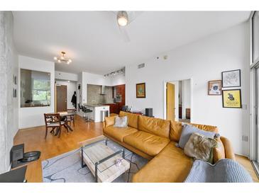 Open living room featuring a leather sofa, hardwood floors, and modern decor with eat-in kitchen in background at 130 Arizona Ne Ave # 214, Atlanta, GA 30307
