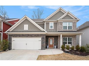 Beautiful two-story home featuring stone accents, a two-car garage, and a charming front porch swing at 214 Gaston Ct, Canton, GA 30115