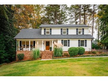 Inviting two-story home showcasing a brick foundation, covered front porch, and a well-manicured lawn at 1477 Brawley Ne Cir, Brookhaven, GA 30319