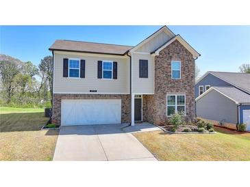 Charming two-story home featuring a stone facade, attached two-car garage, and well-maintained landscaping at 5530 Bower Pl, Cumming, GA 30028