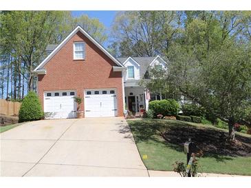Charming two-story brick home with a well-manicured lawn, two car garage and lush landscaping at 561 Valleyside Dr, Dallas, GA 30157