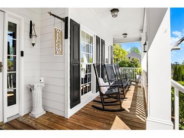 Inviting front porch featuring rocking chairs, wood floors, and a 