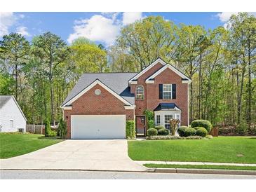 Charming brick home with a well-manicured lawn, two-car garage, and lush landscaping at 2523 Bancroft Way, Buford, GA 30519