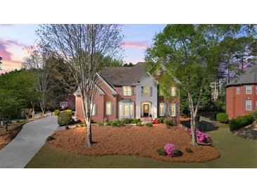 Two-story home boasts manicured landscaping, brick and siding exterior, and a welcoming entrance at 6690 Stillmeadow Dr, Cumming, GA 30040