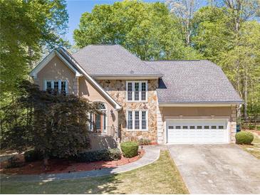 Charming home featuring a stone facade, well-manicured lawn, and attached two-car garage at 255 Sageglen Rd, Lawrenceville, GA 30044