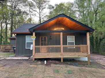 Charming home featuring a covered front porch, wooden trim, and a chandelier under the porch roof at 3244 Mount Olive Rd, Atlanta, GA 30344