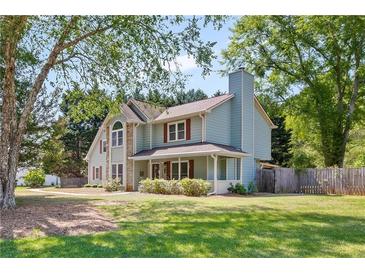 Charming two-story home featuring light blue siding, a cozy front porch, and a well-manicured lawn at 4531 Cedar Dr, Loganville, GA 30052