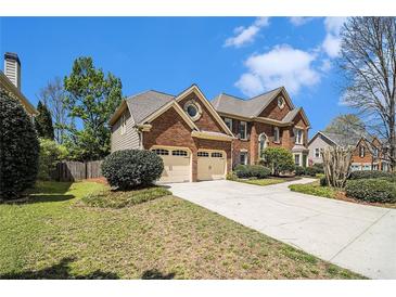 Charming brick home featuring an attached two-car garage, beautiful landscaping, and a spacious driveway at 5222 Camden Lake Nw Pkwy, Acworth, GA 30101