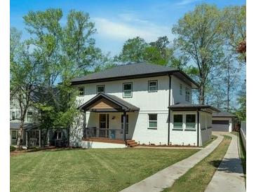 Charming two-story home featuring a white facade, dark trim, and a well-manicured front lawn at 917 Derrydown Way, Decatur, GA 30030