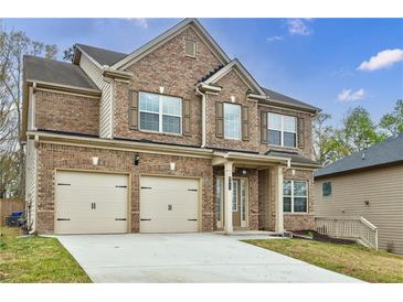 Charming brick two-story home featuring a two-car garage, shuttered windows and manicured lawn at 8045 Hillside Climb Way, Snellville, GA 30039