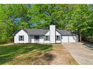 Charming one-story home with white siding, green shutters, two car garage and mature trees at 9347 Haley Ct, Jonesboro, GA 30238