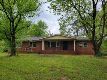 Charming brick home featuring a covered front porch and a large, grassy yard at 4758 Highway 81, Mcdonough, GA 30252
