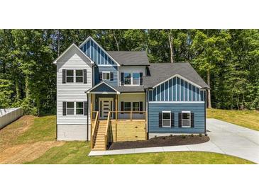 Charming two-story home with a blue and white exterior, complemented by a wooden porch and lush greenery at 492 Mary Hill Ln, Douglasville, GA 30134