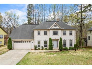 Charming two-story home featuring a manicured front lawn and attached two-car garage at 300 Radner Run, Lawrenceville, GA 30043