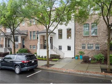 Charming townhome exterior with a manicured lawn and front yard in a desirable neighborhood at 3932 Boston Common St, Suwanee, GA 30024