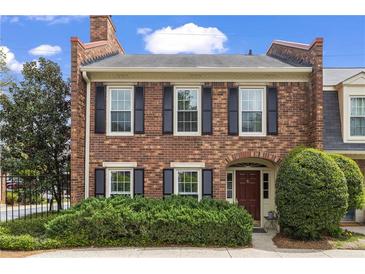 Charming two-story brick townhome featuring black shutters and manicured landscaping at 1 James River Ne Pl, Atlanta, GA 30342