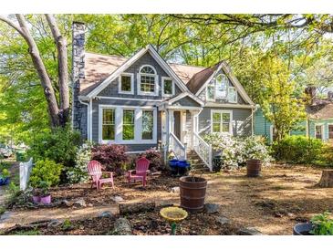 Charming two-story home with a landscaped front yard featuring a stone chimney and flowering bushes at 1326 Metropolitan Se Ave, Atlanta, GA 30316
