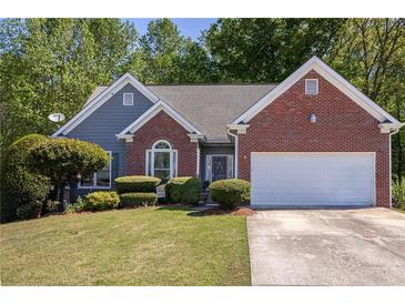 Charming home showcasing a well-manicured lawn and lush landscaping, enhancing its curb appeal at 1570 Hill Crossing Ct, Grayson, GA 30017