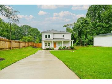 Charming two-story home features a well-manicured lawn, covered porch, and a cozy seating area at 90 Cerro St, Atlanta, GA 30314