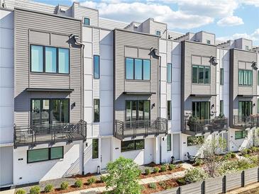 Beautiful exterior of modern townhomes with gray and white siding and private balconies on multiple levels at 443 Plateau Nw Pl, Atlanta, GA 30309