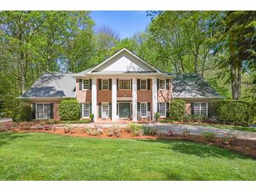Beautiful brick home featuring a stately facade with large columns, lush landscaping, and a well-manicured lawn at 2000 Old Dominion Rd, Atlanta, GA 30350