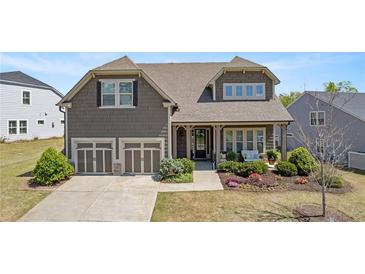 Charming two-story home with a well-manicured lawn, two-car garage, and inviting front porch at 347 Woodridge Pass, Canton, GA 30114
