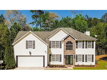 Charming two-story home with a two-car garage, stone accents and inviting curb appeal nestled amongst mature trees at 3554 Cherry Bloom Way, Decatur, GA 30034