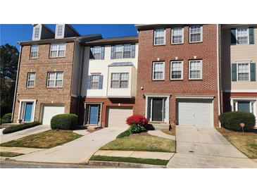 Charming townhomes with brick and siding exteriors, manicured lawns, and attached garages at 528 Lantern Wood Dr, Scottdale, GA 30079