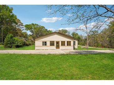 Charming single story home with spacious yard, concrete driveway, and mature trees at 961 Old Conyers Rd, Stockbridge, GA 30281