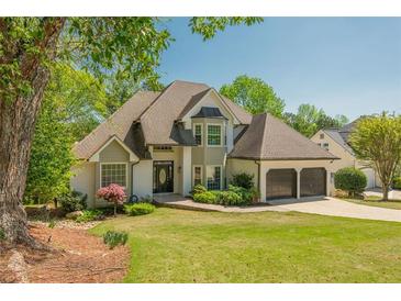 Charming two-story home with well-manicured lawn, a two-car garage, and mature trees enhancing its curb appeal at 10575 Wren Ridge Rd, Alpharetta, GA 30022