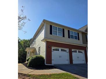 View of exterior highlighting brick and siding with a two-car garage and landscaping at 1960 Dakota Nw Dr, Acworth, GA 30101